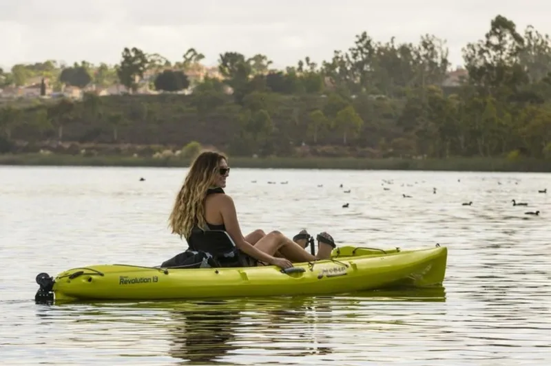 Slide: The Image of Woman kayaking on a lake in a 2023 Hobie Revolution 13. - 13