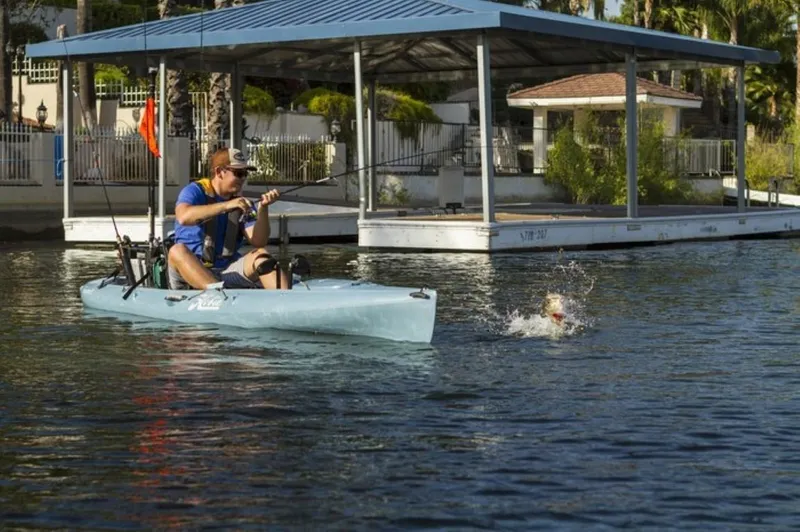 Slide: The Image of Man fishing from a 2023 Hobie Revolution 13 kayak on a calm lake. - 4
