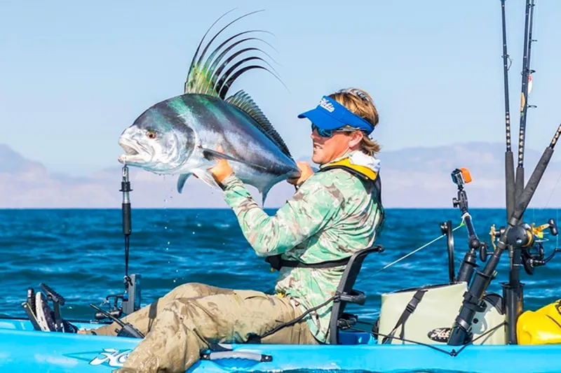 Slide: The Image of Man holding a large fish on a 2023 Hobie Revolution 13 kayak. - 5