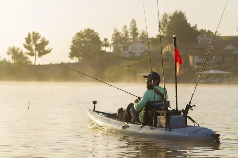 Slide: The Image of Man fishing on a 2023 Hobie Revolution 13 kayak in a serene lake. - 7