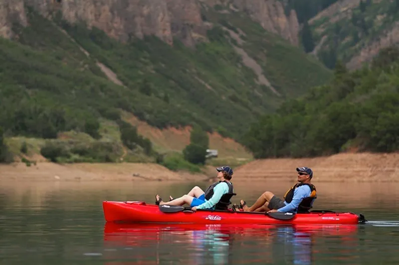 Slide: The Image of Two people kayaking on a 2022 Hobie Mirage Oasis in a scenic lake. - 2