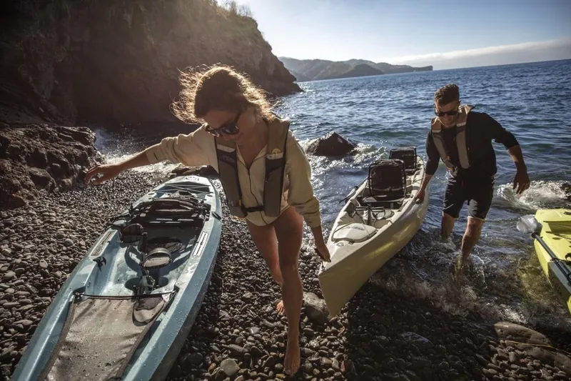 Slide: The Image of Couple with Hobie Mirage Oasis kayaks on rocky beach, 2022 model. - 4