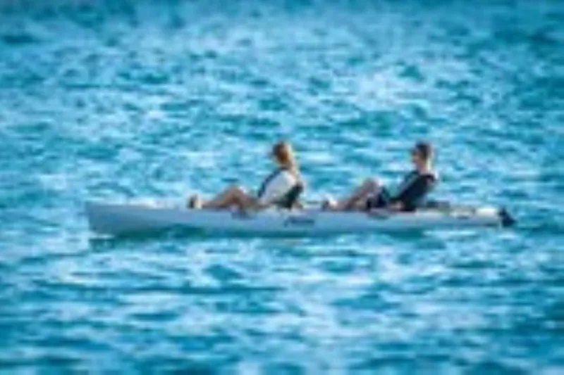 Slide: The Image of Two people kayaking on a 2022 Hobie Mirage Oasis in blue water. - 8