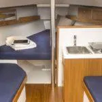 Slide: The Image of 2025 Saffier SC 8M Cabin interior with blue cushions and compact kitchenette. - 10