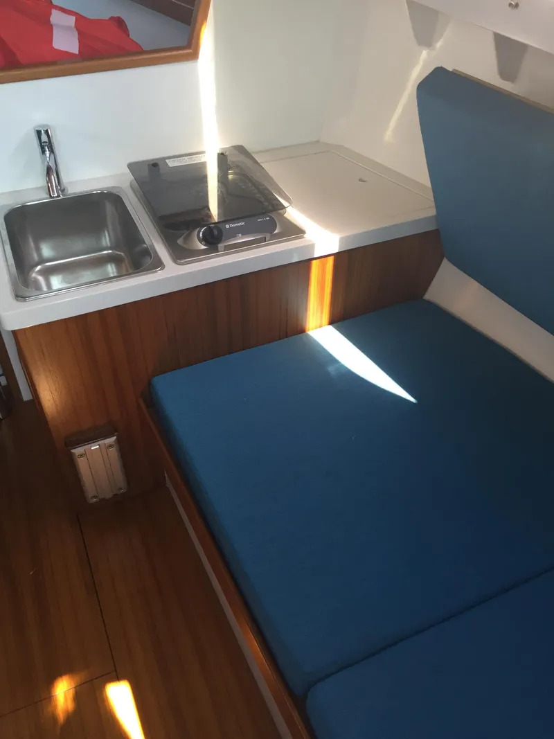 Slide: The Image of 2025 Saffier SC 8M Cabin interior with sink, stove, and blue seating. - 13