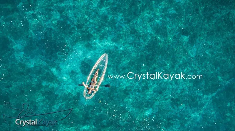 Slide: The Image of Aerial view of a person kayaking in a 2023 Crystal Kayak Explorer on clear blue water. - 4