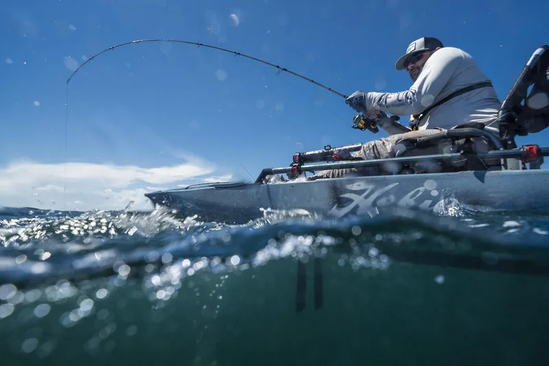Slide: The Image of Man fishing from a 2023 Hobie Mirage Pro Angler 14 kayak with 360 Drive Technology. - 13