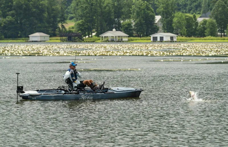 Slide: The Image of Angler fishing from a 2023 Hobie Mirage Pro Angler 14 with 360 Drive Technology on a lake. - 14