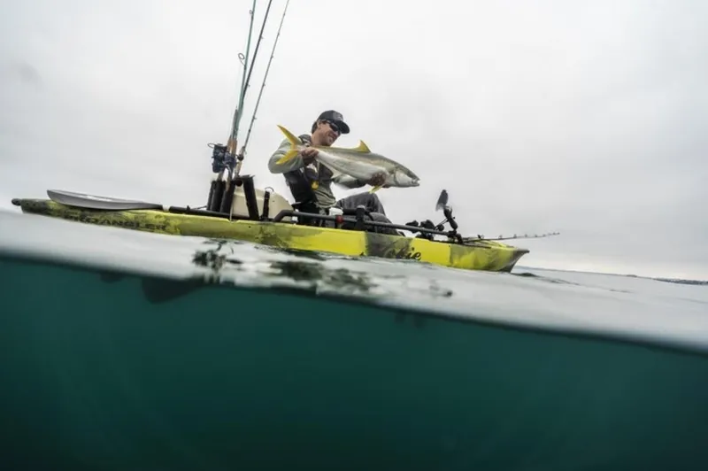 Slide: The Image of Angler on Hobie Mirage Pro Angler 12 kayak with 360 Drive Technology holding a fish, 2023 model. - 3