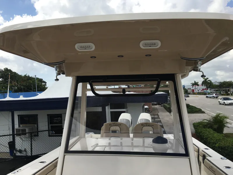 Slide: The Image of 2026 Sea Chaser 35 HFC boat with T-top and dual seating, parked near a building. - 13