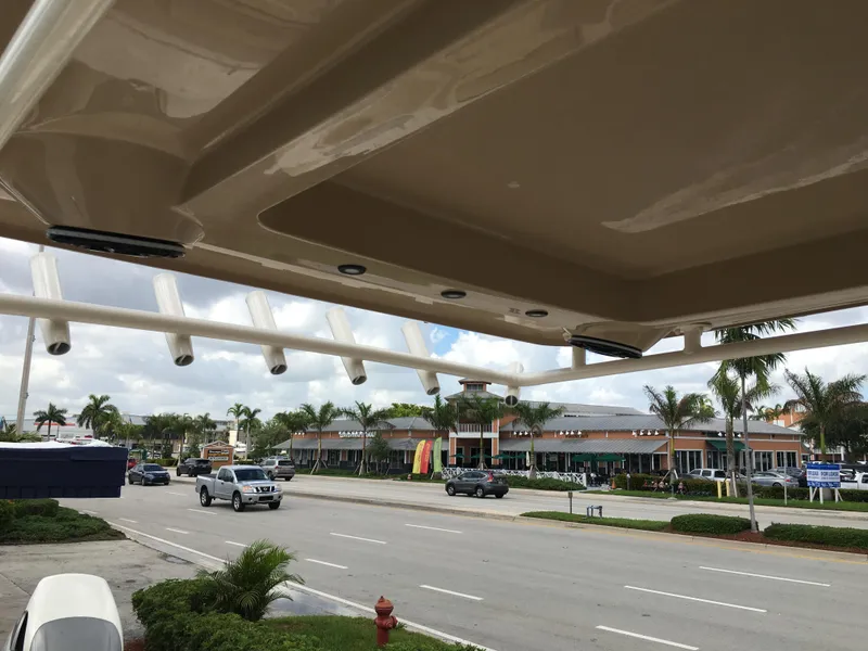 Slide: The Image of 2026 Sea Chaser 35 HFC boat view from street, showcasing rod holders and canopy. - 20