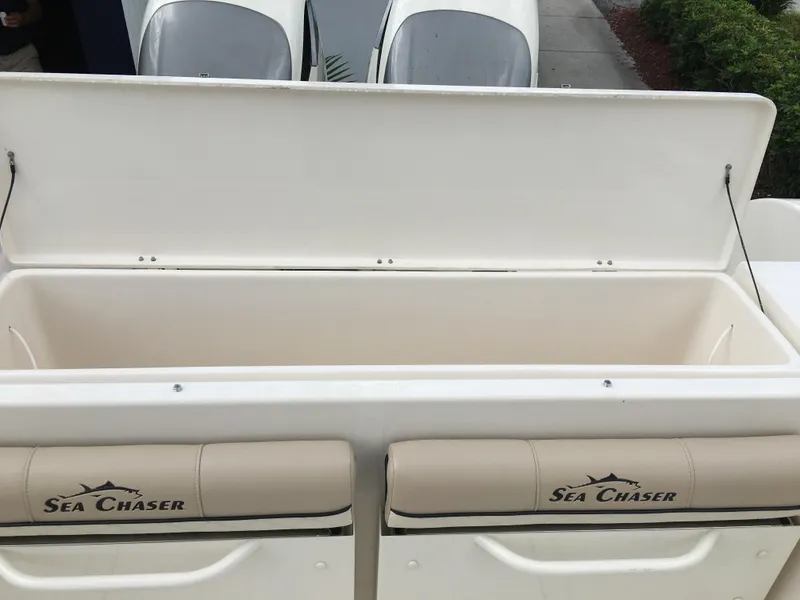 Slide: The Image of 2026 Sea Chaser 35 HFC boat storage compartment with open lid and branded seating. - 30