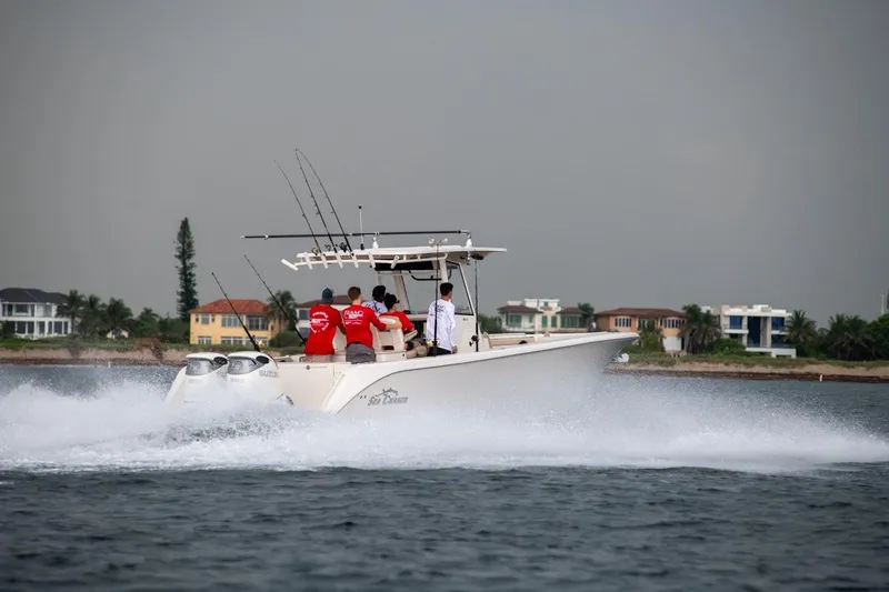 Slide: The Image of 2026 Sea Chaser 35 HFC boat speeding on water with passengers, coastal homes in background. - 42