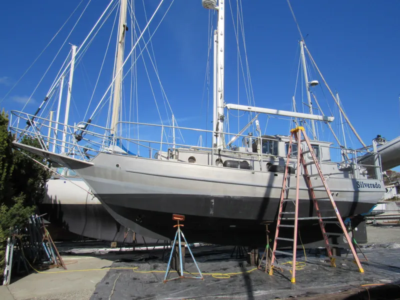 Slide: The Image of Custom 2009 Pilothouse Cutter sailboat on dry dock with ladders and clear blue sky. - 2