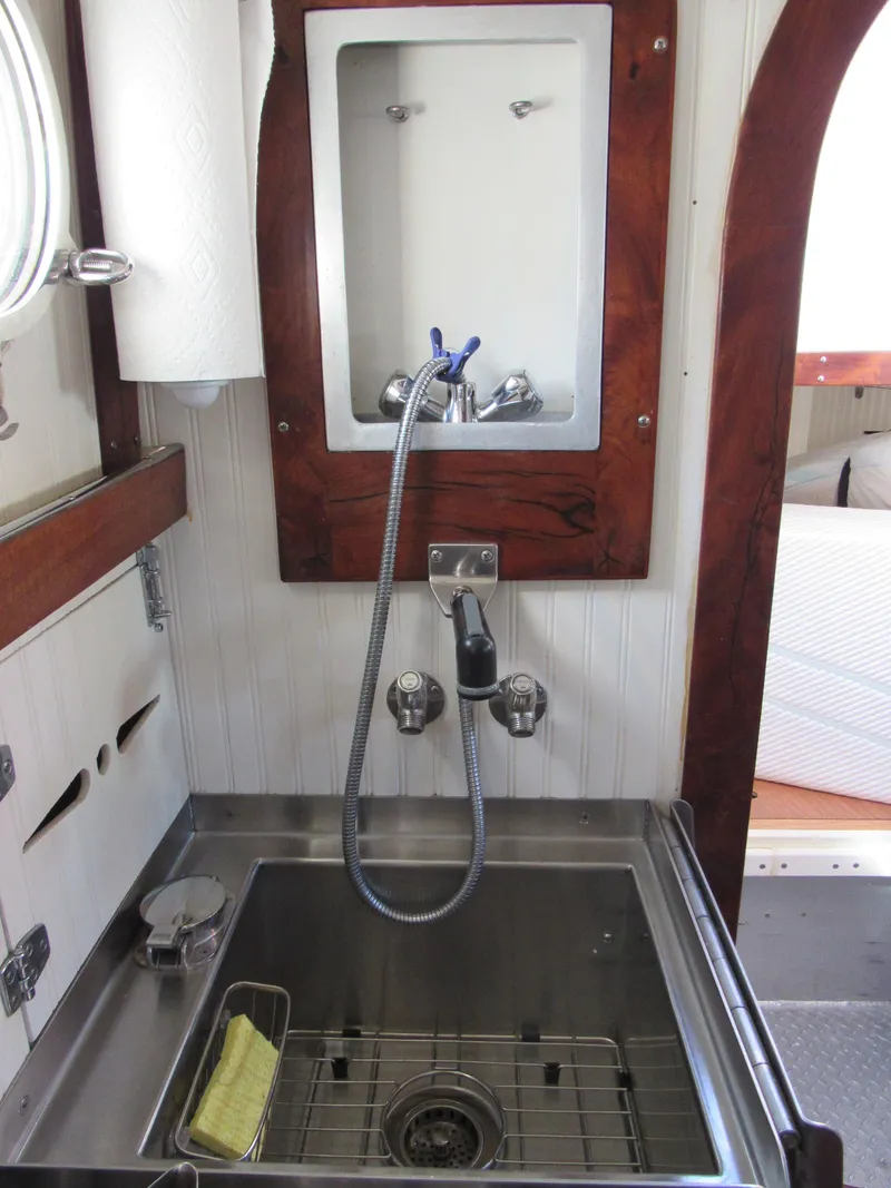 Slide: The Image of 2009 Custom Pilothouse Cutter interior with stainless steel sink and wooden accents. - 23