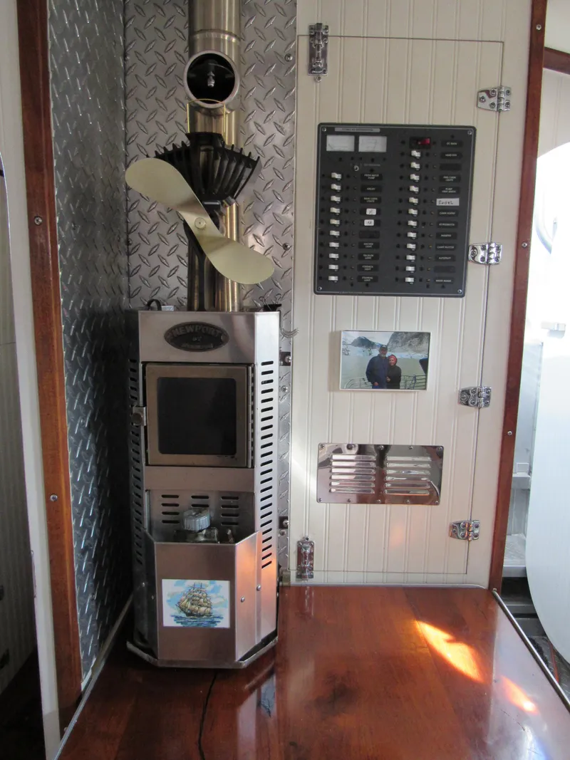Slide: The Image of 2009 Custom Pilothouse Cutter interior with stove, control panel, and wood flooring. - 24