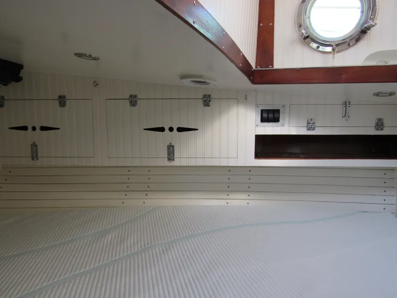 Slide: The Image of Interior of 2009 Custom Pilothouse Cutter with white cabinetry and porthole window. - 31