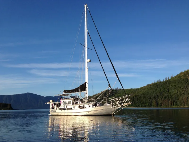 Slide: The Image of Custom 2009 Pilothouse Cutter sailboat on calm water with forested hills in the background. - 35