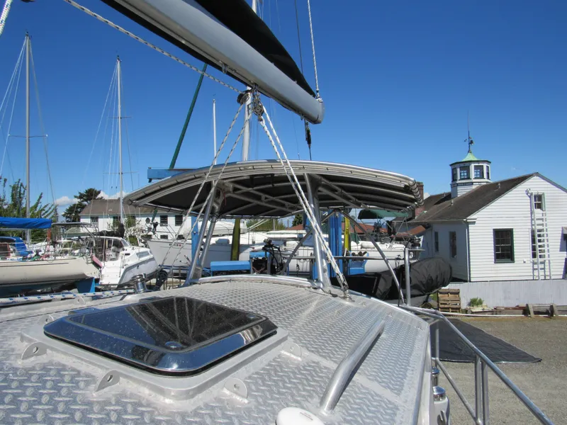 Slide: The Image of Custom 2009 Pilothouse Cutter sailboat docked, featuring a sleek deck and clear blue sky. - 37