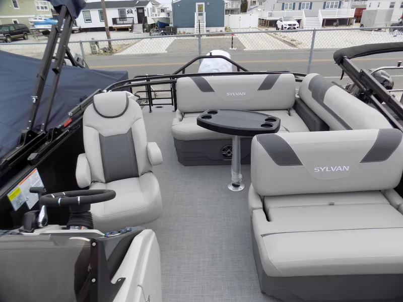 Slide: The Image of 2023 Sylvan L3 CLZ pontoon boat interior with gray seating and table. - 4