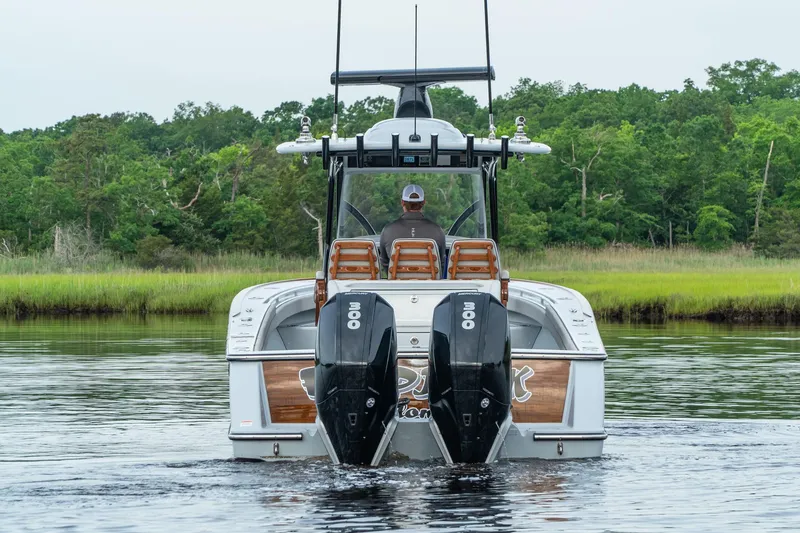 Slide: The Image of 2025 Valhalla Boatworks V-33 with twin outboard engines on a calm river. - 2