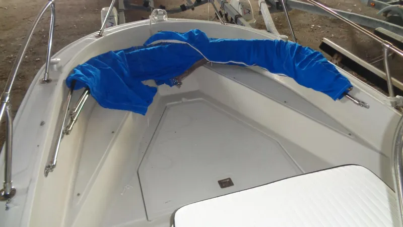 Slide: The Image of 1987 Boston Whaler 18 Outrage boat interior with blue cover on railing. - 12
