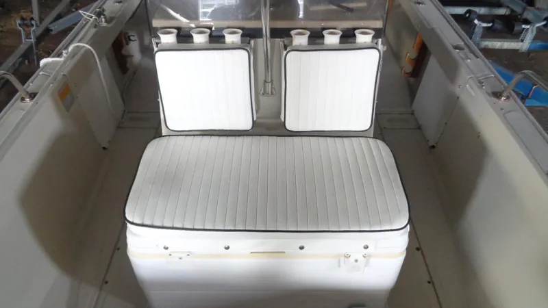 Slide: The Image of 1987 Boston Whaler 18 Outrage interior with white cushioned seating and rod holders. - 13