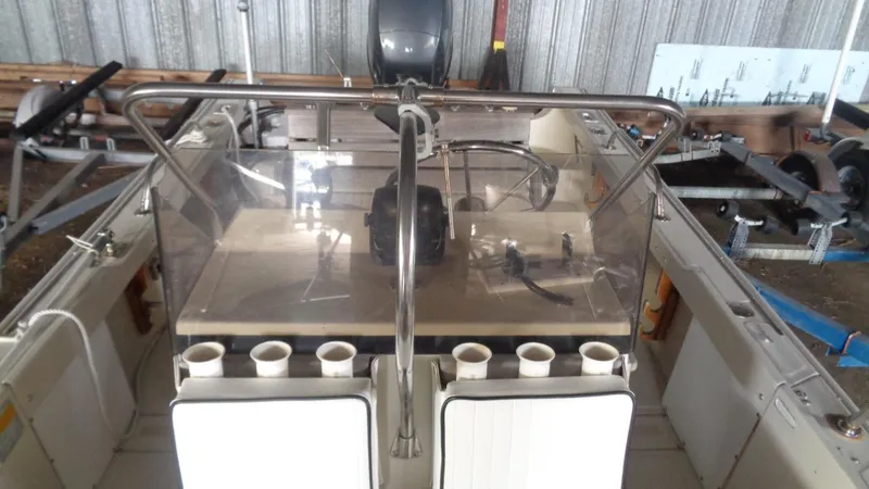 Slide: The Image of 1987 Boston Whaler 18 Outrage boat interior with steering console and rod holders. - 14