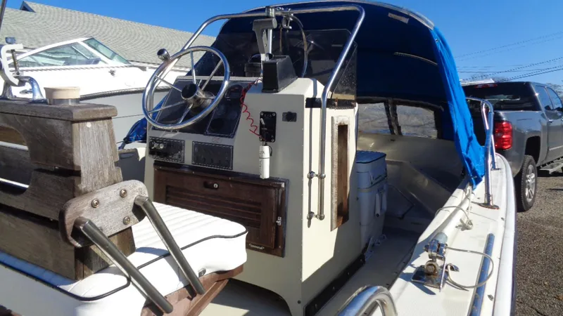 Slide: The Image of 1987 Boston Whaler 18 Outrage boat with blue canopy and classic helm design. - 19