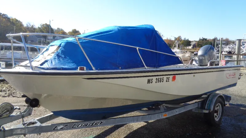 Slide: The Image of 1987 Boston Whaler 18 Outrage boat on trailer, covered with blue tarp. - 2