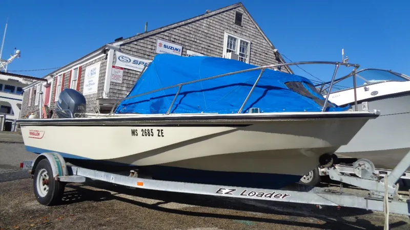 Slide: The Image of 1987 Boston Whaler 18 Outrage boat on EZ Loader trailer, covered with blue tarp. - 3