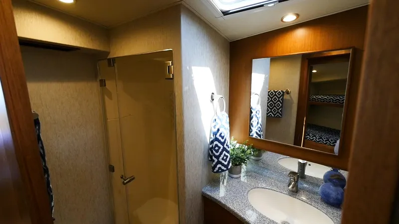 Slide: The Image of 2025 Henriques 50 EXHT yacht bathroom with shower, vanity, and mirror. - 12