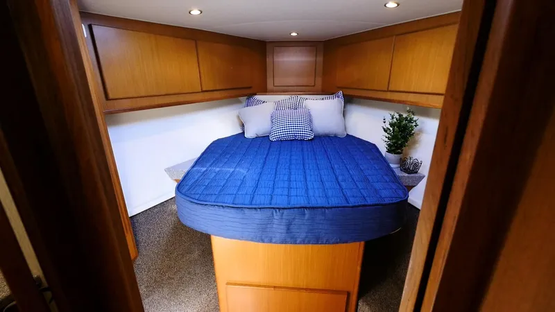Slide: The Image of Cozy bedroom in 2025 Henriques 50 EXHT yacht with blue bedding and wooden cabinets. - 13