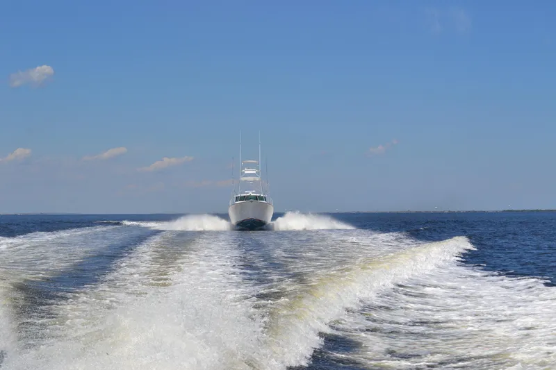 Slide: The Image of 2026 Henriques 50 EXHT yacht cruising on open water, leaving a wake behind. - 2