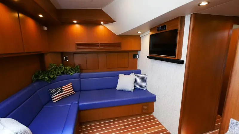 Slide: The Image of Luxurious interior of 2025 Henriques 50 EXHT yacht with blue seating and wooden finishes. - 9