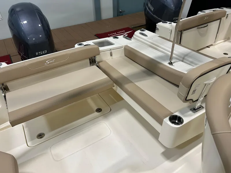 Slide: The Image of 2024 Scout 215 Dorado boat interior with beige seating and twin 150 horsepower engines. - 10