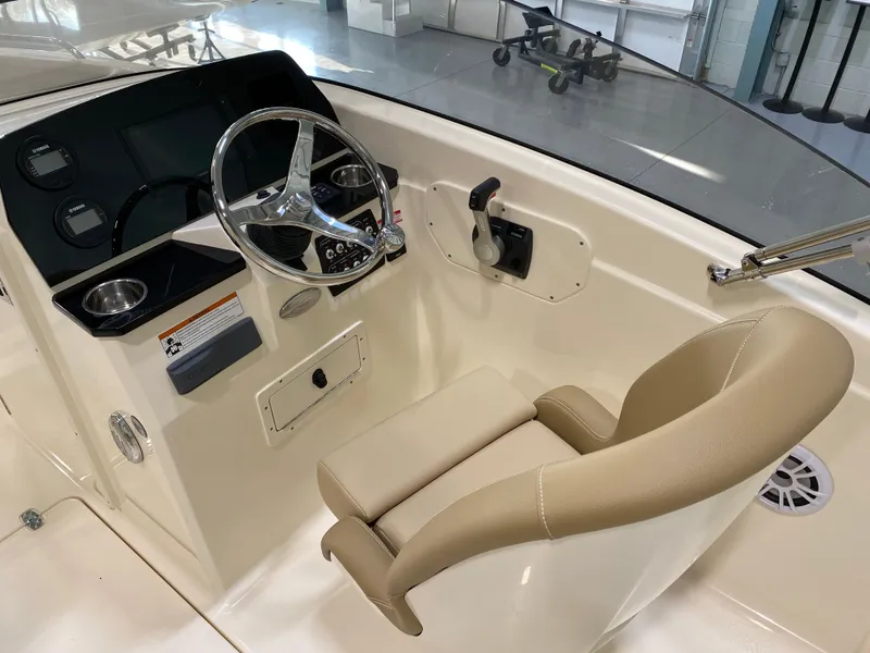 Slide: The Image of 2024 Scout 215 Dorado boat helm with steering wheel and beige captain's chair. - 3