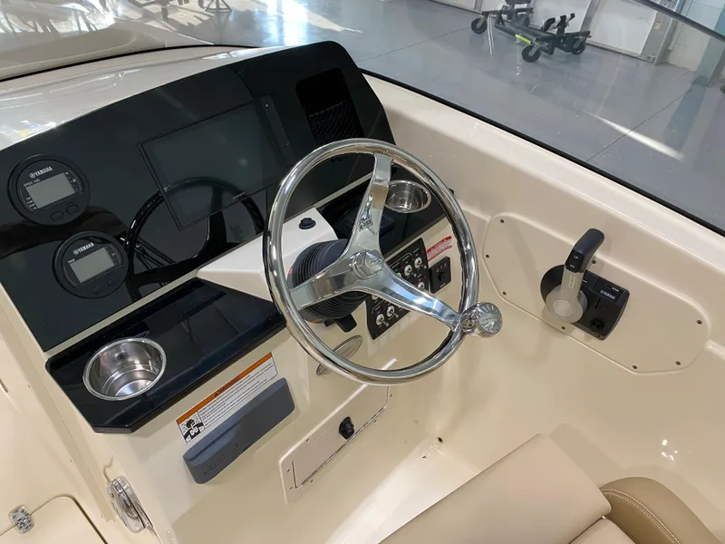 Slide: The Image of 2024 Scout 215 Dorado boat dashboard with steering wheel and controls. - 4