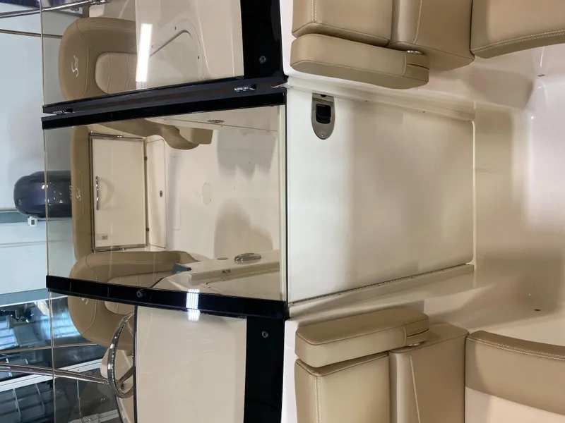 Slide: The Image of 2024 Scout 215 Dorado boat interior with beige seating and glass windshield. - 6