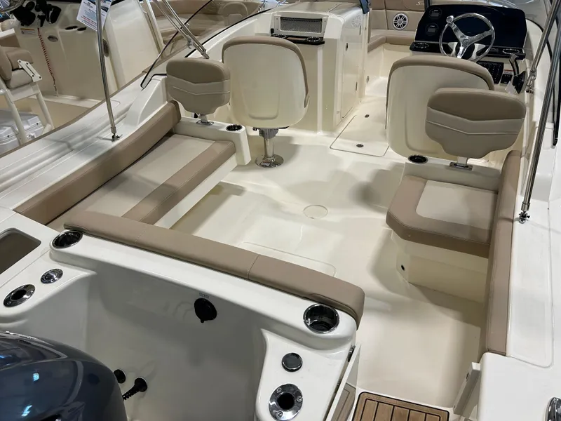 Slide: The Image of 2024 Scout 215 Dorado boat interior with beige seating and modern dashboard. - 8