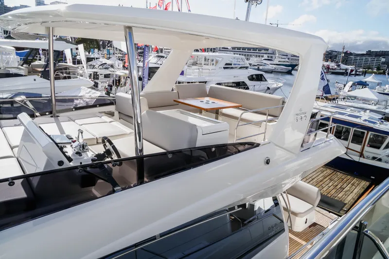 Slide: The Image of 2024 Prestige 590 yacht with spacious upper deck and luxurious seating. - 19