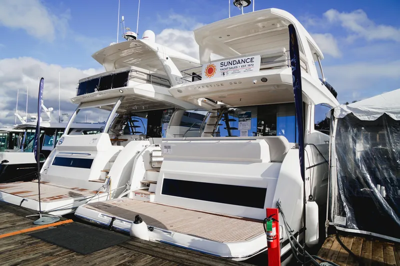 Slide: The Image of 2024 Prestige 590 yachts docked at a marina under a clear sky. - 5