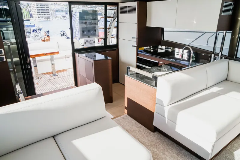Slide: The Image of Luxurious interior of 2024 Prestige 590 yacht with modern kitchen and white seating. - 8