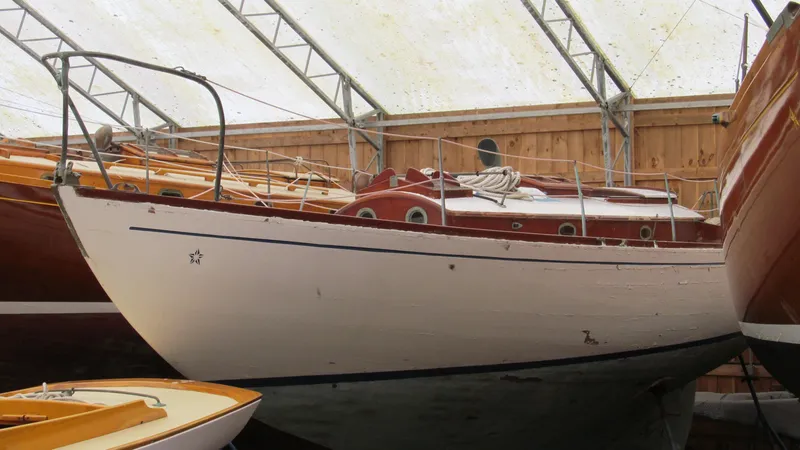 Slide: The Image of 1951 Concordia Yawl sailboat in storage, showcasing classic wooden design and craftsmanship. - 2