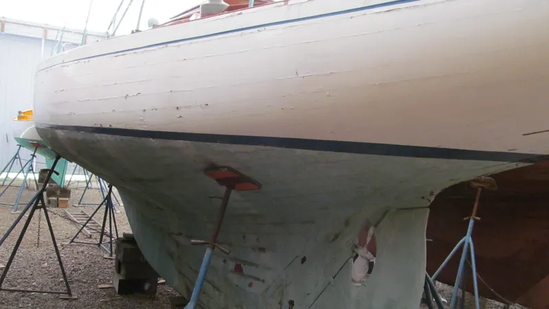 Slide: The Image of 1951 Concordia Yawl sailboat on stands, showcasing its classic wooden hull design. - 3