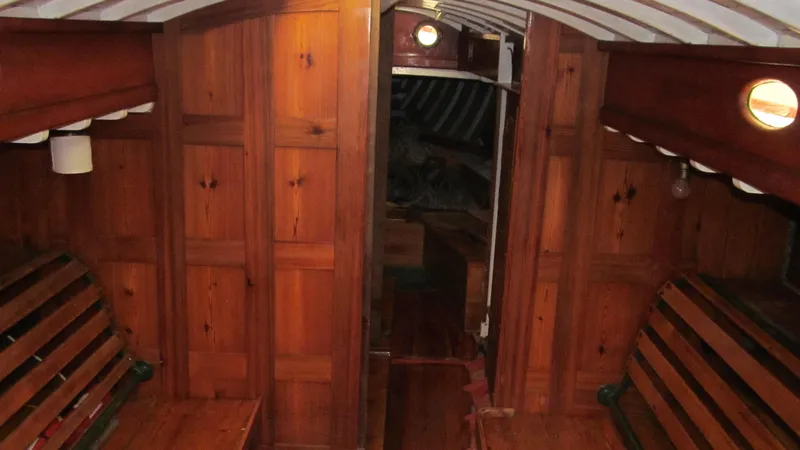 Slide: The Image of Interior of a 1951 Concordia Yawl, featuring wooden paneling and benches. - 8