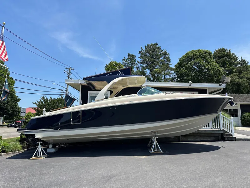 The Image of 2025 Chris-Craft Launch 35 GT boat displayed outdoors on stands, under clear blue sky. - 0