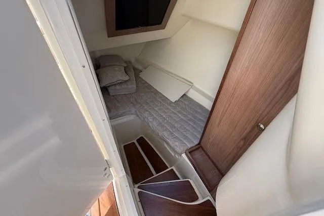 Slide: The Image of 2025 Chris-Craft Launch 35 GT cabin interior with bed and wooden accents. - 10