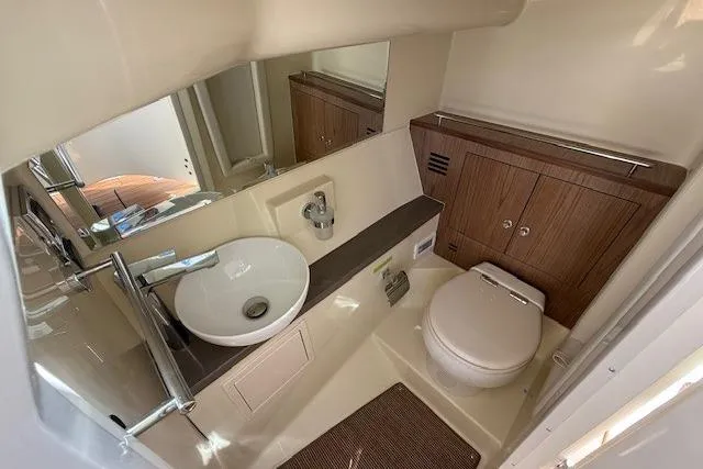 Slide: The Image of 2025 Chris-Craft Launch 35 GT boat bathroom with modern sink and wooden cabinetry. - 11