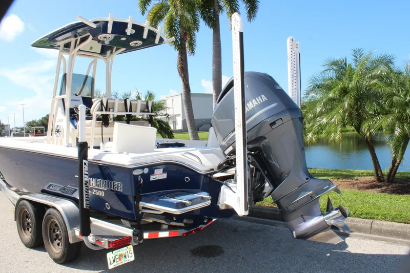 Slide: The Image of 2017 Pathfinder 2500 Hybrid boat with Yamaha engine on trailer, near palm trees and water. - 12